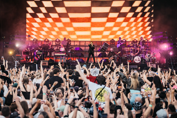 Pulp performing at Tramlines 2025. Jarvis Cocker is centre stage, with a large crowd looking on with their arms in the air.