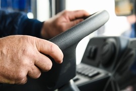 Hands driving a bus wheel