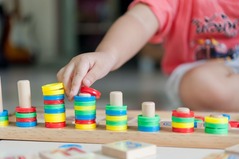 A child's hands playing with wooden stacking blocks
