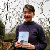 Marrianne Brown holds her book to the camera