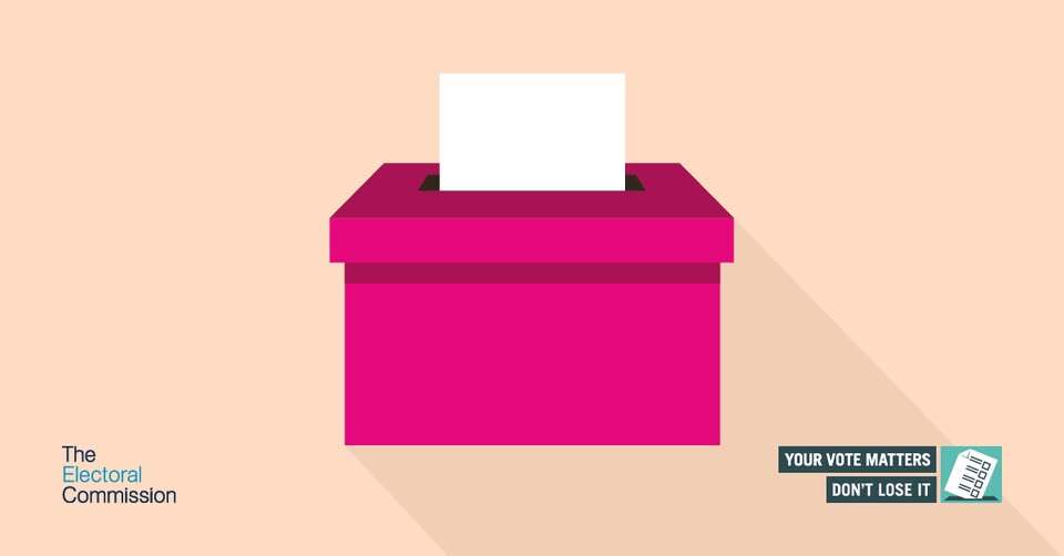 A pink ballot box with a slip poking out the top