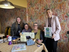 Ann from the climate team with repair cafe participants, around a sewing machine