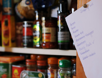 Shopping list pinned on kitchen cupboard