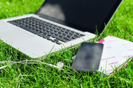 Laptop and phone on grass