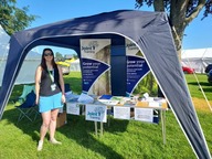 Nicola Davies standing in front of a stand displaying Joint Training leaflets and handouts 