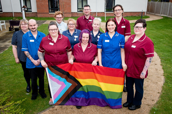 carers standing with rainbow flag