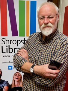 Bill Dorrell, programme participant in front of shropshire libraries sign
