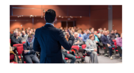 crowd of people siting at a conference