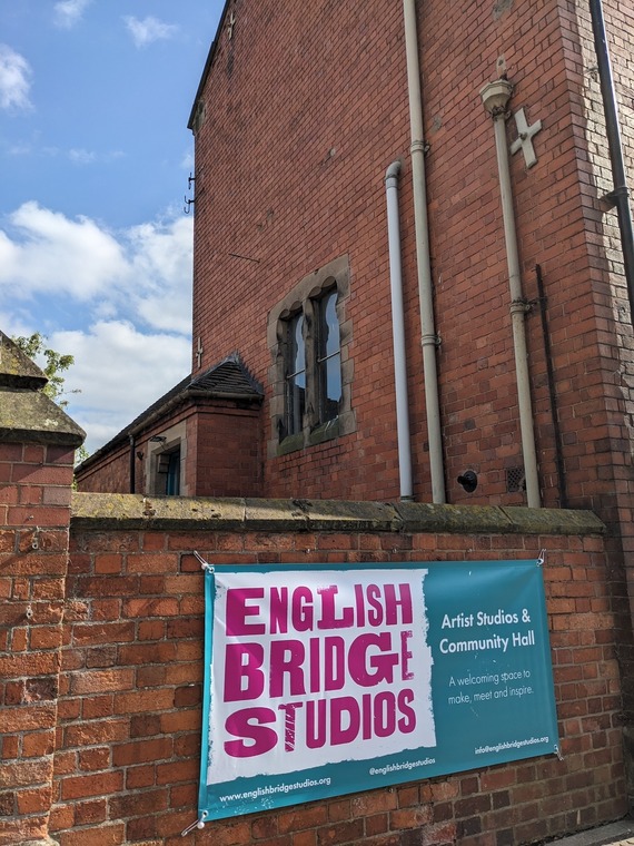 a banner hangs from a brick wall reading 'english bridge studios'