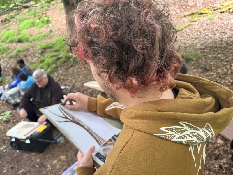 photograph of people sketching in woodland