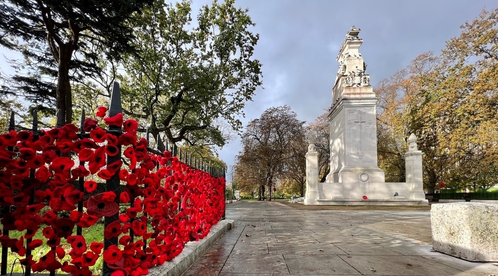 Cenotaph in Watts Park with knitted poppies on railing to the left