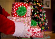 Santa's hands holding a pile of presents stacked on top of each other