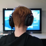 Young person wearing gaming headset sitting in front of a screen