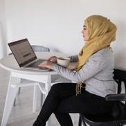 Lady sat at a table using a laptop