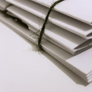 Stack of white report papers on a table tied with green twine