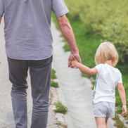 Man and child holding hands view from the back.
