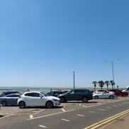 Cars parked on seafront parking.