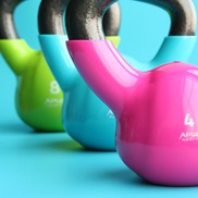 Three brightly coloured kettlebell weights on a cyan background.