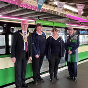 The Mayor and Mayoress with members of pier staff in front of the stationed green and white pier train.