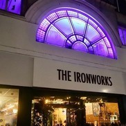 Front entrance of the Ironworks with a window lit up purple.