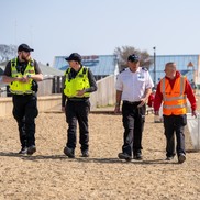 Two Community Support Officers walking along Jubilee beach with a Veolia employee and Seafront resort staff.