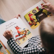 Child and parent reading a book about a fox who has lost his socks.