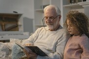 Elderly man reading with a child