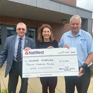 Two Southend council representatives, posing for a photo with a member of Havens Hospice. They are all holding a giant cheque for 12,000 pounds.