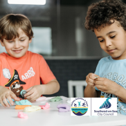 Two children playing with plasticine at a table