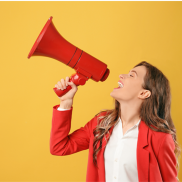 A woman with blonde hair in a red blazer holding a red megaphone on a yellow background.