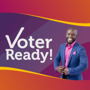 Voter ready. A black man in a smart blue suit, he is smiling.