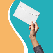 A persons arm in a dark coloured shirt sleeve, in their hand they're holding a white envelope aloft on a pale orange and aqua background. 