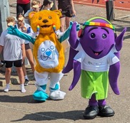 A yellow bear and a purple octopus as mascots at the Invicible Games 2024.