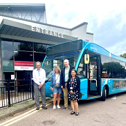 Four people stand in front of a blue arrive bus outside the entrance to Southend Leisure and Tennis centre