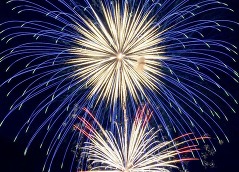 Blue, yellow and red fireworks in the dark sky.