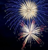 Blue, yellow and red fireworks in the dark sky.