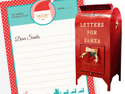 A close up of a decorated letter for Santa and a red letter box.