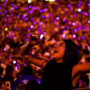 A young lady is singing and enjoying the moment at a packed concert.