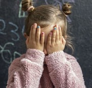 Child covering her eyes