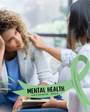 Two people indoors, one with their head resting on their hand, and the other with a supportive hand on their shoulder.