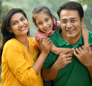A family outdoors, looking at the camera and smiling