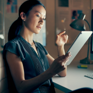 The profile of a woman using a tablet.