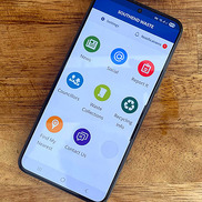 A mobile phone showing the Southend Waste App on screen, resting on a wooden table
