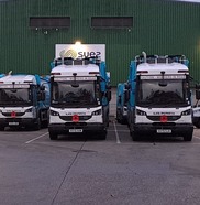 Three waste collection vehicles with poppies on the front bumper grill.