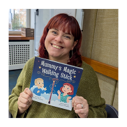 Headshot of Lynsey Garrick holding her book. She is looking at the camera and smiling.