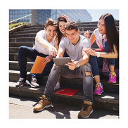 A group of 4 young people looking at a tablet together. They are outdoors, sitting on a set of stairs.