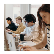 A group of young people in a line working on computers.