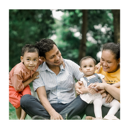 A family of two adults and 2 children outdoors.