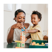 A Black British child and mother playing with a wooden blocks.