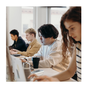 A group of young people working on laptops.